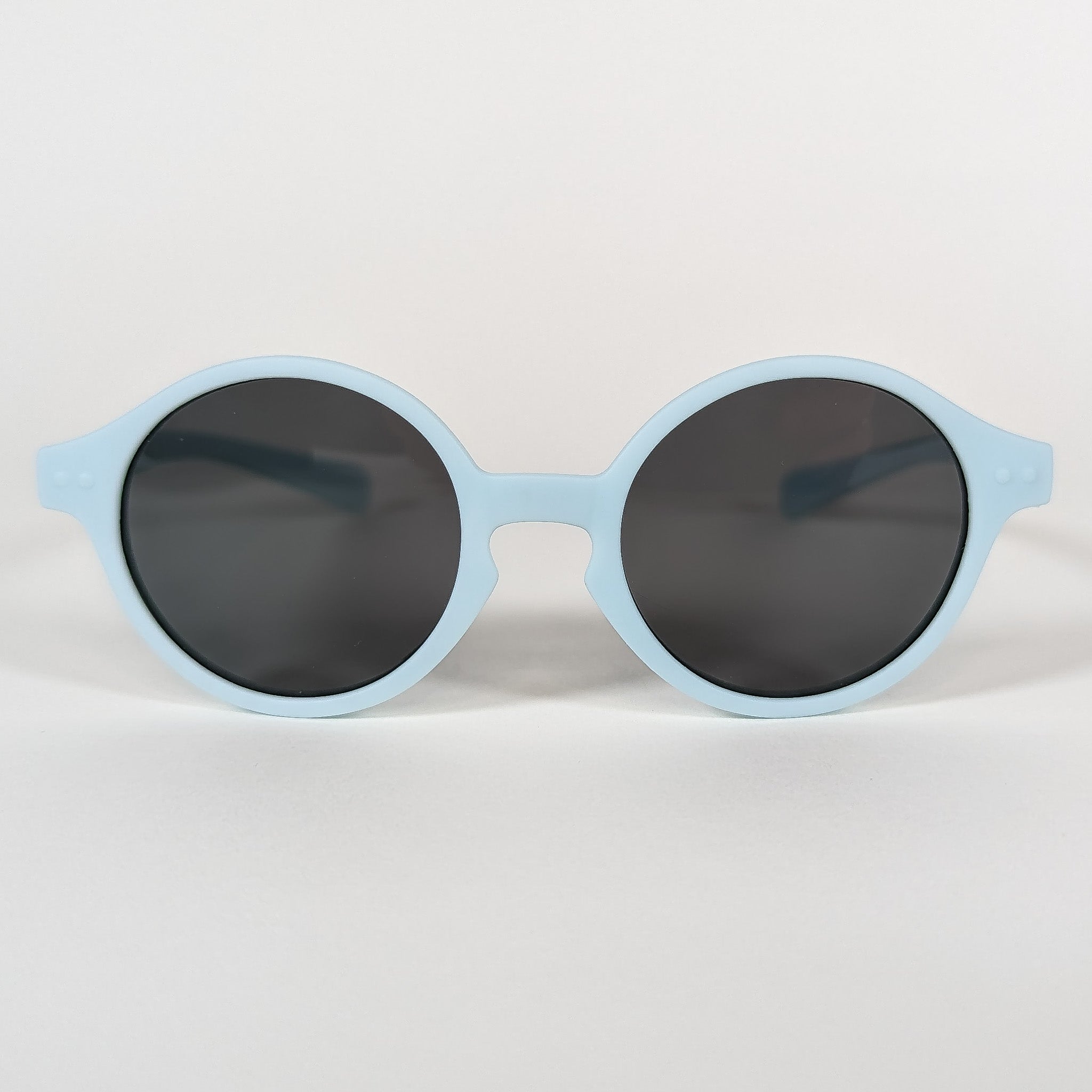 Zoomed in view of baby sunglasses with a blue frame and round lenses.