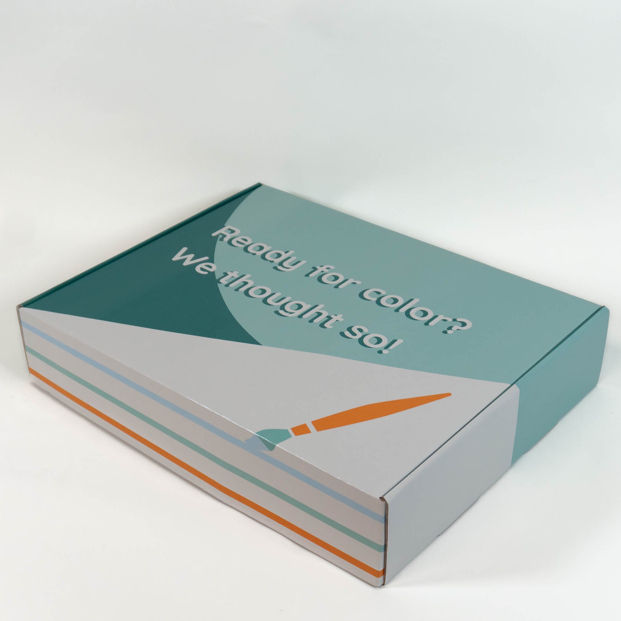 A close up of the outside of the Ready for Color box design, showing a green background with a paintbrush and multicolored stripes with the phrase "Ready for color? We thought so!" on the top.