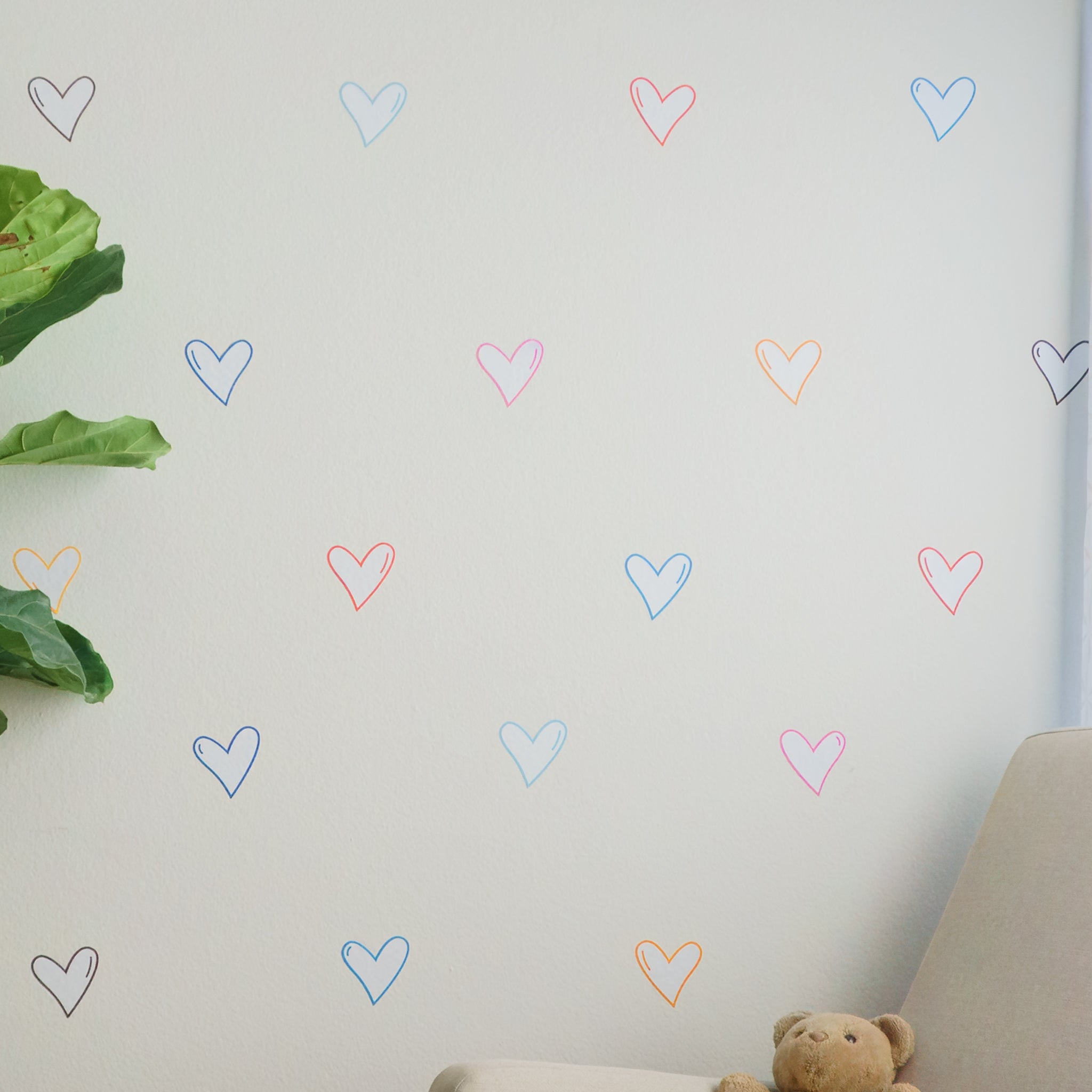 White wall with staggered heart decals in different colors, including pink, orange, red, light blue and dark blue.