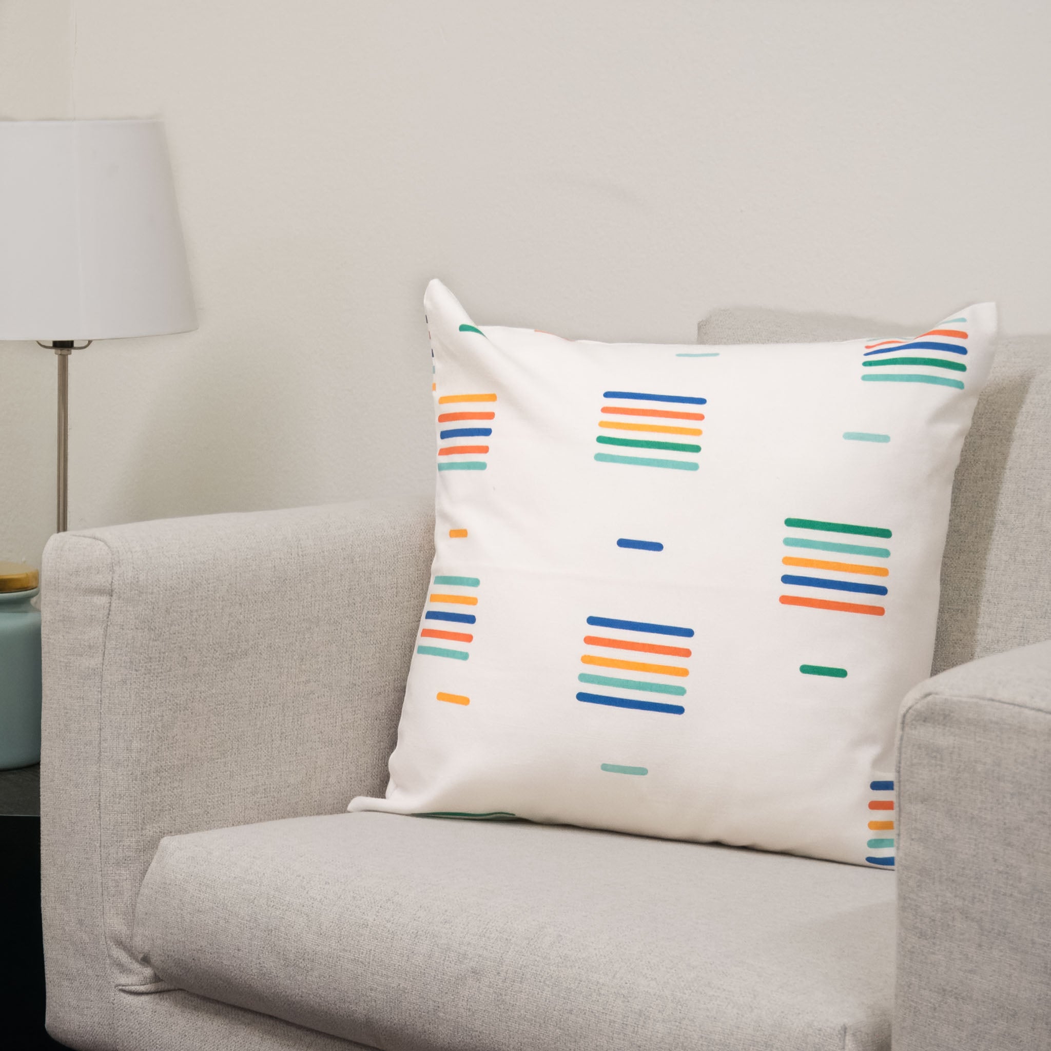 Ready for Color Collection throw pillow cover sitting on chair, showing multicolored stripe pattern